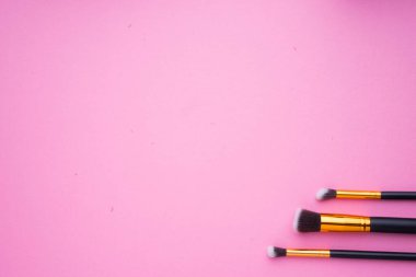Pembe arka planda kozmetik ürünlerinin yaratıcı düzenlenmesi.