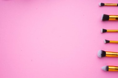 Pembe arka planda kozmetik ürünlerinin yaratıcı düzenlenmesi.