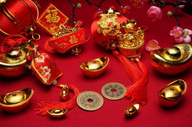 Kırmızı arkaplan ve çeşitli festival dekorasyonlarıyla Çin Yeni Yıl dekorasyonları. Çince karakterler zenginlik, refah ve şans demektir. Düz yatıyordu.