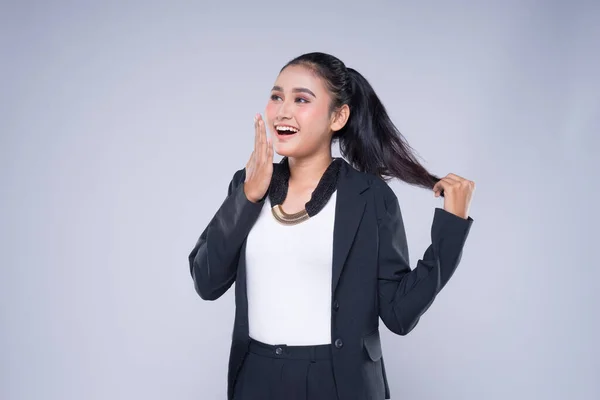 An attractive woman wearing business attire with gestures towards copyspace area isolated on grey. Good for manipulation works for technology, transportation, business or finance theme.