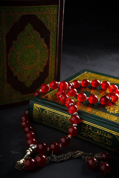 Faith in Islam concept. The Islamic holy book Quran or Kuran with rosary beads or tasbih on dark background.