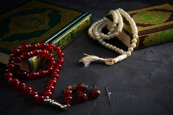 Faith in Islam concept. The Islamic holy book Quran or Kuran with rosary beads or tasbih on dark background.