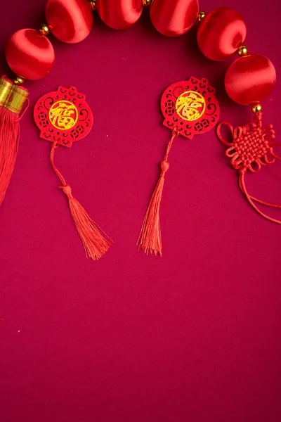 Chinese New Year decorations with red background with assorted festival decorations. Chinese characters means abundant of wealth, prosperity and luck. Flat lay.