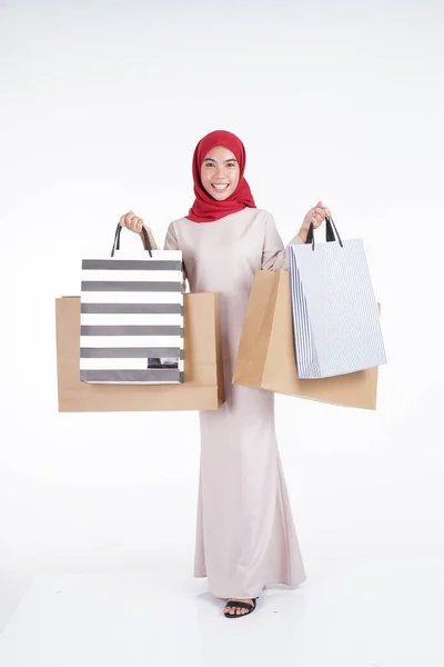 一位美丽而兴奋的穆斯林女模特穿着亚洲传统服装 身穿现代木瓜 提着白色背景的购物袋 Eidul Fitri时尚和节日准备购物概念 — 图库照片