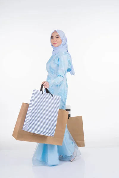 一位漂亮的穆斯林女模特穿着亚洲传统服饰 穿着时髦的和服 背着白色背景的购物袋 Eidul Fitri节庆准备购物概念 全长肖像 — 图库照片