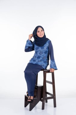 Çeşitli pozlarda güzel bir kadın model modern kurung ve tesettüre bürünmüş, beyaz arka planda soyutlanmış Müslüman kadınlar için modern şehir tarzı bir kıyafet. Güzellik ve tesettür moda konsepti. Tam uzunluk.