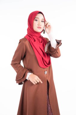 Modern kebaya elbisesi ve tesettür giyen güzel bir kadın modelin yarım boy portresi, beyaz arka planda izole edilmiş Müslüman kadınlar için bir yaşam tarzı. Güzellik ve tesettür moda konsepti.