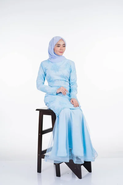 Attractive Muslim female model wearing pastel blue modern kurung with hijab, a urban lifestyle apparel for Muslim women isolated on white background. Beauty and hijab fashion concept. Full length