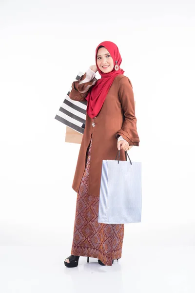 一位漂亮的穆斯林女模特穿着亚洲传统服饰 穿着现代木瓜 提着白色背景的购物袋 Eidul Fitri节庆准备购物概念 全长肖像 — 图库照片