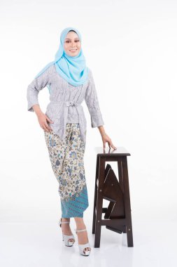 Modern kebaya ve tesettüre giyerek poz veren güzel bir kadın model, beyaz arka planda izole edilmiş Müslüman kadınlar için kentsel bir yaşam tarzı. Güzellik ve tesettür moda konsepti. Tam uzunluk