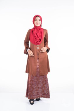 Modern kebaya elbisesi ve tesettüre bürünmüş güzel bir kadın modelin tam boy portresi, beyaz arka planda izole edilmiş Müslüman kadınlar için bir yaşam tarzı. Güzellik ve tesettür moda konsepti.