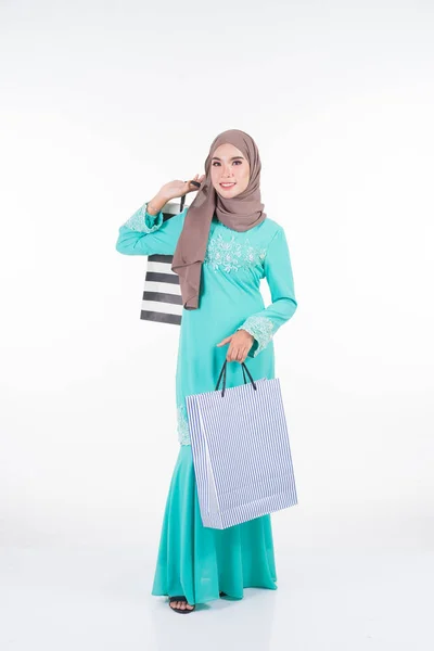 白を基調としたショッピングバッグを背負ったアジアの伝統的なドレス現代のクルンで美しく 興奮したイスラム教徒の女性モデル Eidul Fitriお祝いの準備ショッピングコンセプト 全長像 — ストック写真