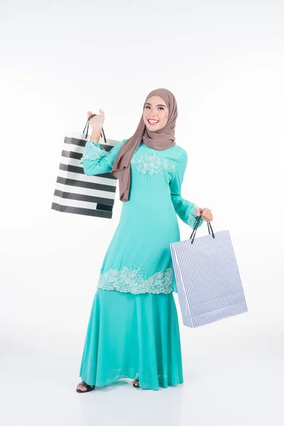 白を基調としたショッピングバッグを背負ったアジアの伝統的なドレス現代のクルンで美しく 興奮したイスラム教徒の女性モデル Eidul Fitriお祝いの準備ショッピングコンセプト 全長像 — ストック写真