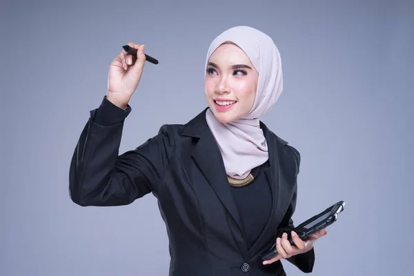 一半长的肖像一个有吸引力的穆斯林女商人穿着头巾与石碑和手势隔离灰色背景 用于企业 商业或金融的图像剪裁 — 图库照片