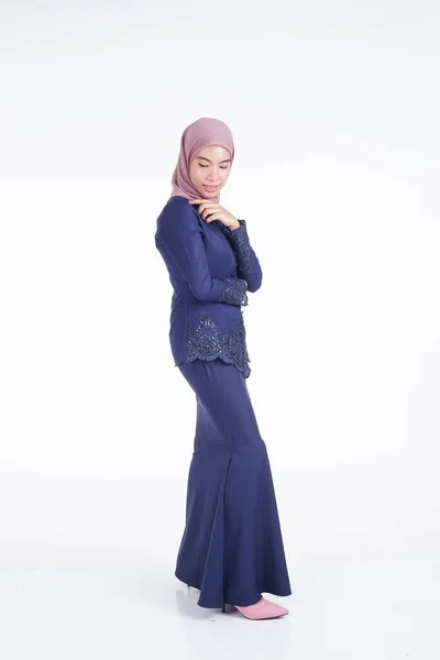 一位漂亮的穆斯林女模特 身穿深蓝色的现代木瓜 头戴头巾 是亚洲穆斯林传统服饰 背景为白色 Eidul Fitri时尚和生活方式肖像画概念 — 图库照片