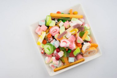 Beyaz arka planda renkli şeker ve şekerlerin yaratıcı düzenlemesi. Düz görünüm.