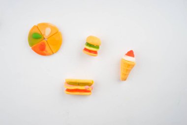 Beyaz arka planda renkli şeker ve şekerlerin yaratıcı düzenlemesi. Düz görünüm.