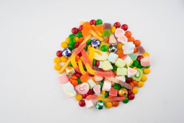 Beyaz arka planda renkli şeker ve şekerlerin yaratıcı düzenlemesi. Düz görünüm.