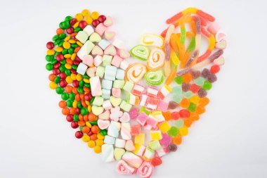 Beyaz arka planda renkli şeker ve şekerlerin yaratıcı düzenlemesi. Düz görünüm.