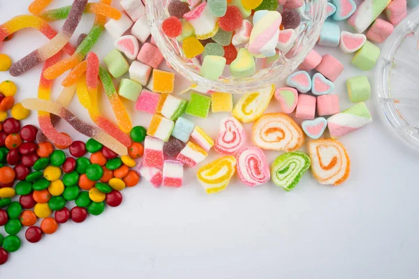 白い背景にカラフルなキャンディーやお菓子の創造的な配置 平面図 — ストック写真