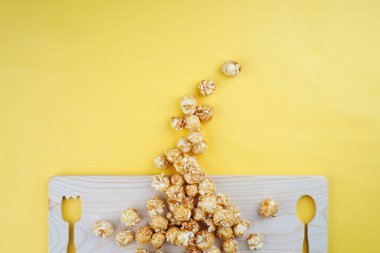 Film ya da eğlence konsepti. Sarı arka planda patlamış mısır. Düz görünüm.