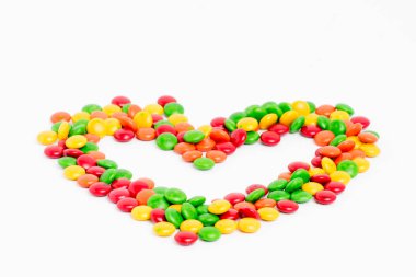 Beyaz arkaplanda renkli şeker ve tatlıların yaratıcı düzenlenmesi