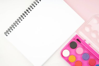 Okula dönüş konsepti. Kalem, kalem, suluboya ve diğerleri gibi kırtasiyelerin düz görünümü ışık arkaplan üzerinde yaratıcı olarak düzenlenmiştir.