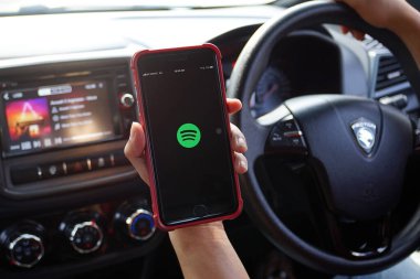 KUALA LUMPUR, MALAYSIA - 28 Mart 2018: Arabasının içinde Spotify uygulaması kullanan bir akıllı telefon kullanıcısı. Spotify popüler bir ticari müzik yayın servisidir..
