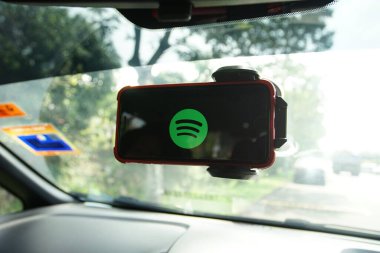 KUALA LUMPUR, MALAYSIA - 28 Mart 2018: Arabasının içinde Spotify uygulaması kullanan bir akıllı telefon kullanıcısı. Spotify popüler bir ticari müzik yayın servisidir..
