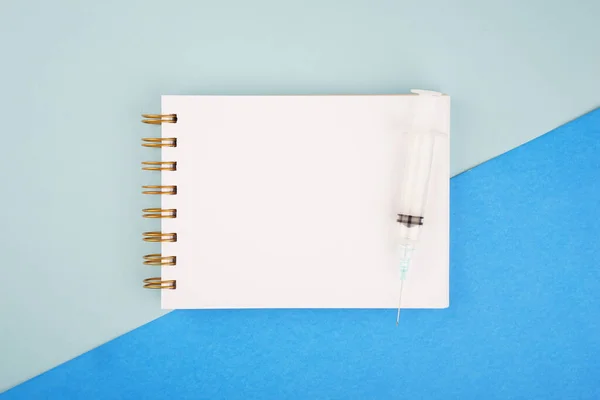 Medical or healthcare concept. Medical apparatus such as stethoscope and spiral notepad on blue background. Flat lay view.