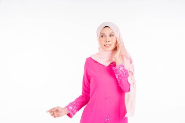 Pembe modern kurung giyen güzel bir kadın model, beyaz arka planda soyutlanmış Müslüman kadınlar için modern şehir tarzı bir kıyafet. Güzellik ve tesettür moda konsepti.