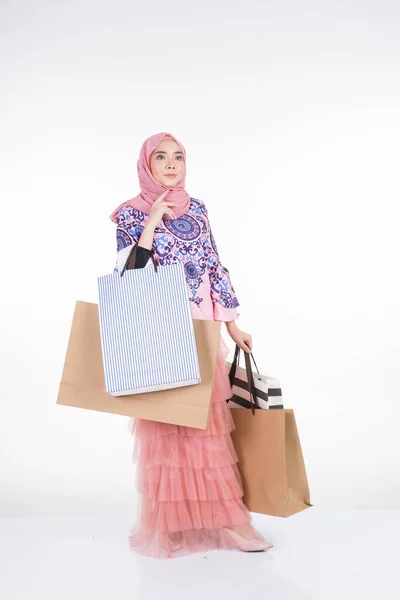 一位漂亮的穆斯林女模特 身穿亚洲传统服装 背着白色背景的购物袋 Eidul Fitri节庆准备购物概念 全长肖像 — 图库照片