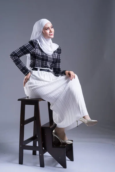 Full length portrait of a beautiful Muslim female model in a hijab and casual wear on grey background. Hijab and Muslim fashion lifestyle concept