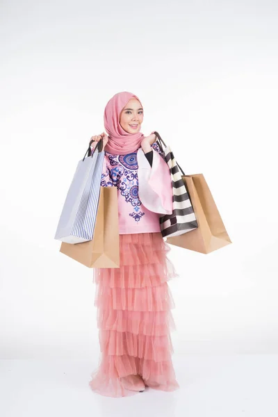 一位漂亮的穆斯林女模特 身穿亚洲传统服装 背着白色背景的购物袋 Eidul Fitri节庆准备购物概念 全长肖像 — 图库照片