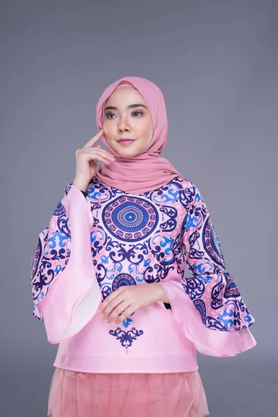 Beautiful Muslim female model wearing modern apparel with hijab, a urban lifestyle apparel for Muslim women isolated on grey background. Beauty and hijab fashion concept. Half length