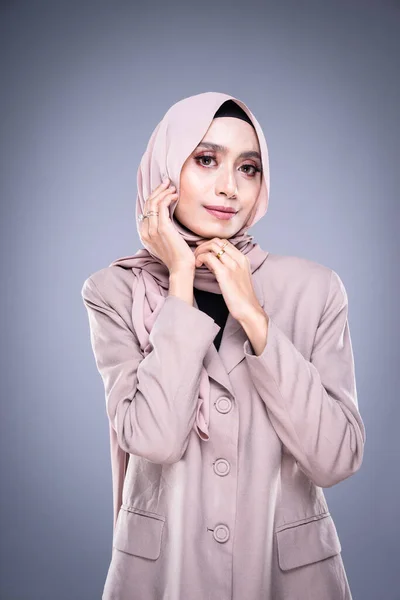 Half length portrait of a beautiful Muslim female model in a hijab and officewear isolated on grey background. Hijab and Muslim fashion lifestyle concept