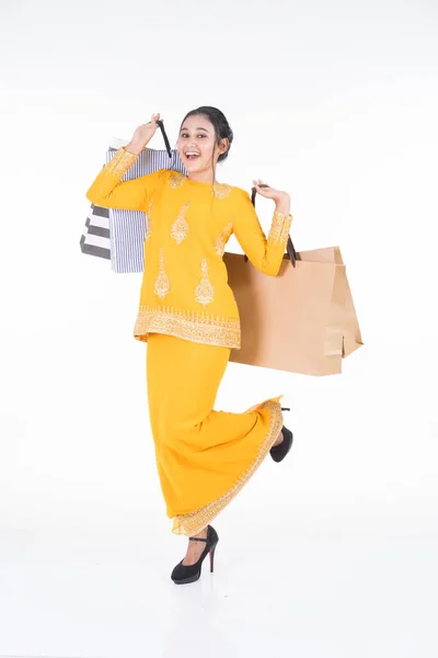 一位漂亮的亚洲女模特 穿着传统的服装 穿着现代和服 背着白色背景的购物袋 Eidul Fitri节庆准备购物概念 全长肖像 — 图库照片