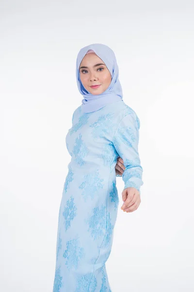 Beautiful Muslim female model wearing pastel blue modern kurung with hijab, a urban lifestyle apparel for Muslim women isolated on white background. Beauty and hijab fashion concept. Half length