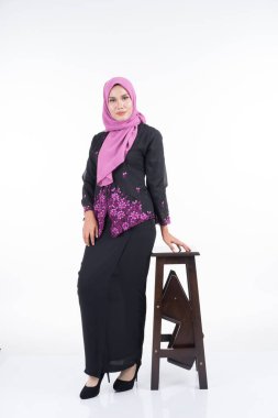 Kebaya ve tesettürde güzel bir kadın modeli, beyaz arka planda soyutlanmış Müslüman kadınlar için modern bir yaşam tarzı. Güzellik ve tesettür moda konsepti. Tam boy portre