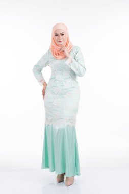 Modern Kurung ve tesettüre sahip güzel bir kadın modeli, beyaz arka planda izole edilmiş Müslüman kadınlar için modern bir yaşam tarzı. Güzellik ve tesettür moda konsepti. Tam boy portre