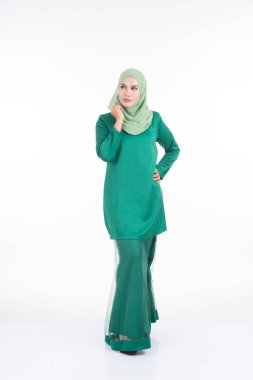 Modern Kurung ve tesettüre sahip güzel bir kadın modeli, beyaz arka planda izole edilmiş Müslüman kadınlar için modern bir yaşam tarzı. Güzellik ve tesettür moda konsepti. Tam boy portre