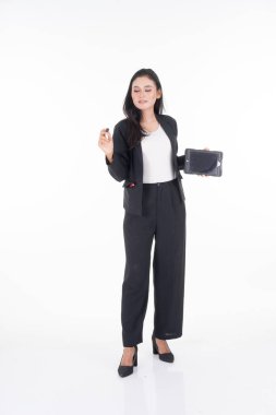 İş kıyafeti giymiş çekici bir kadın elinde tabletle beyaz arka planda izole bir şekilde poz veriyor. Görüntü kesme ve düzenleme için uygun teknoloji, iş veya finans teması için çalışır