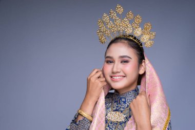 Geleneksel dans kıyafeti giymiş güzel bir Malezyalı kadın dansçının portresi ve büyüleyici bir gülümseme. Gri renkte izole edilmiş.