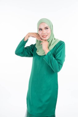 Modern Kurung ve tesettüre sahip güzel bir kadın modeli, beyaz arka planda izole edilmiş Müslüman kadınlar için modern bir yaşam tarzı. Güzellik ve tesettür moda konsepti. Yarım boy portre