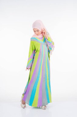 Beyaz arka planda izole edilmiş Müslüman kadınlar için geleneksel bir elbise olan pastel batik kaftan / kaftan giyen güzel bir kadın manken. Tarz sahibi Müslüman kadın tesettür moda tasviri.