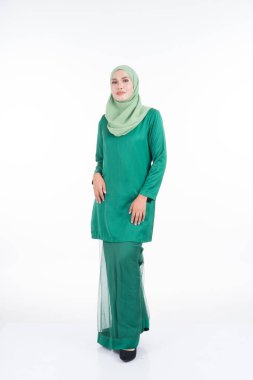 Modern Kurung ve tesettüre sahip güzel bir kadın modeli, beyaz arka planda izole edilmiş Müslüman kadınlar için modern bir yaşam tarzı. Güzellik ve tesettür moda konsepti. Tam boy portre