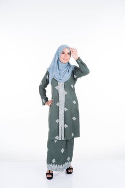 Çeşitli pozlarda güzel bir kadın model modern kebaya ve tesettüre giyer, beyaz arka planda soyutlanmış Müslüman kadınlar için modern şehir tarzı bir kıyafet. Güzellik ve tesettür moda konsepti. Tam uzunluk.