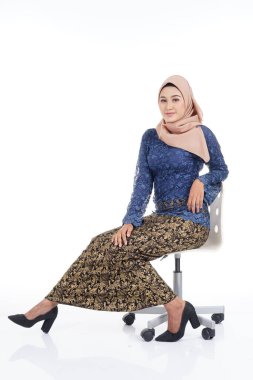 Koyu mavi, tesettürlü ve tesettüre bürünmüş çekici bir kadın model. Beyaz arka planda izole edilmiş Müslüman kadınlar için modern şehir tarzı bir kıyafet. Güzellik ve tesettür moda konsepti.