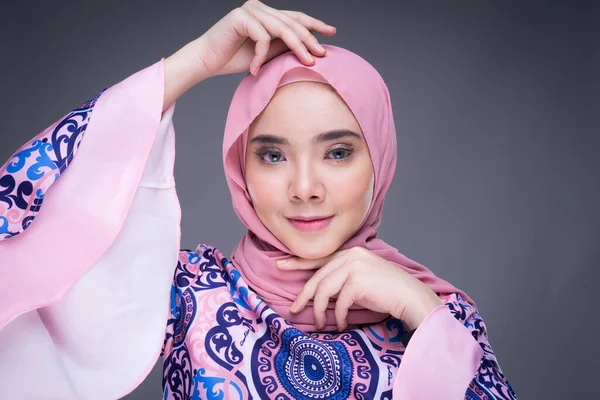 Beautiful Muslim female model wearing modern apparel with hijab, a urban lifestyle apparel for Muslim women isolated on grey background. Beauty and hijab fashion concept. Headshot portrait.