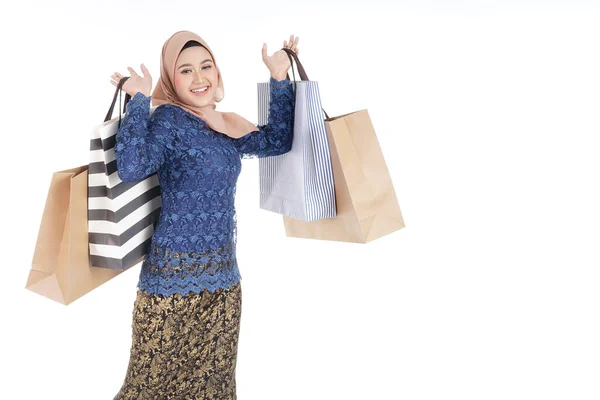 一位美丽而兴奋的穆斯林女模特穿着亚洲传统服饰 穿着时髦的和服 背着白色背景的购物袋 Eidul Fitri时尚和节日准备购物概念 — 图库照片